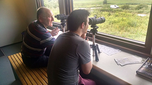 Dad and Dan looking through the binoculars at Cley Visitor Centre